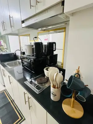 a kitchen with a counter top with utensils at Allie's Cozy Place in Manila