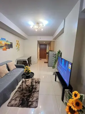 a living room with a couch and a flat screen tv at Staycation Near Mall of Asia in Manila