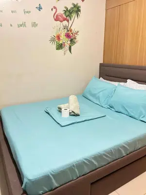 a bed in a room with a tray on it at Staycation Near Mall of Asia in Manila
