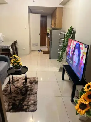 a living room with a flat screen tv on a table at Staycation Near Mall of Asia in Manila