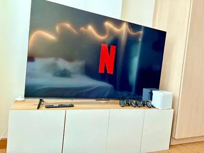 a tv on top of a white cabinet with the letter n on it at Casa de Leon - Azure Urban Resort in Manila