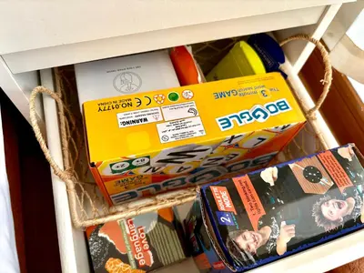 a drawer filled with books and boxes on a shelf at Casa de Leon - Azure Urban Resort in Manila