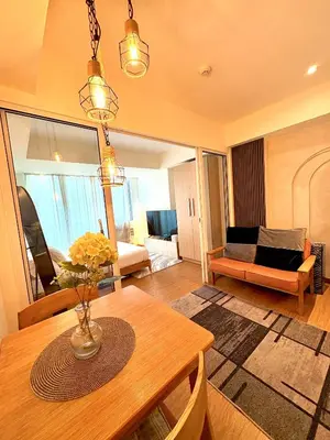 a living room with a table and a room with a couch at Casa de Leon - Azure Urban Resort in Manila