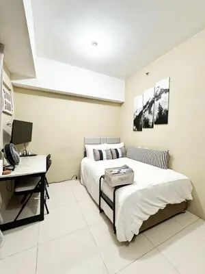a bedroom with a bed and a desk with a computer at Convertible Double Studio in Salcedo Village in Manila