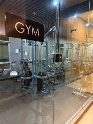a gym with chairs and a sign on a glass wall at Convertible Double Studio in Salcedo Village in Manila