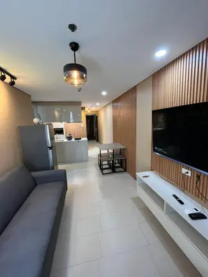 a living room with a couch and a large television at Antel Spa Residences 15A in Manila