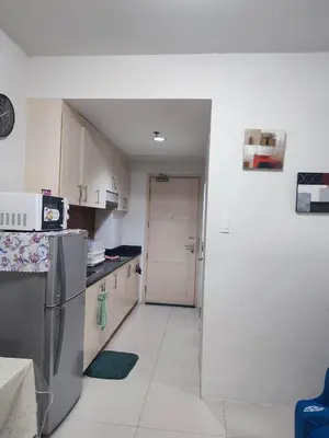 a kitchen with a refrigerator and a door to a room at SM Mall Of Asia Shore Residences Vianny in Manila