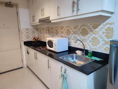 a kitchen with a sink and a microwave on the counter at SM Mall Of Asia Shore Residences Vianny in Manila