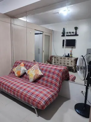a bedroom with a bed with pillows and a fan at SM Mall Of Asia Shore Residences Vianny in Manila