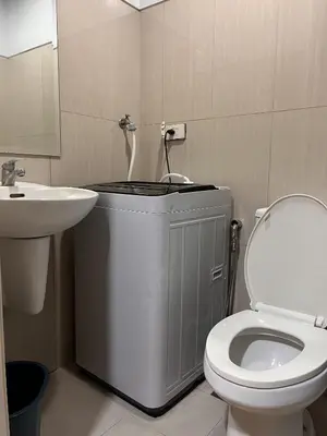 a bathroom with a white toilet and a sink at SM Mall Of Asia Shore Residences Vianny in Manila