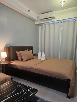 a bedroom with a bed and a window with a air conditioner at SM Mall Of Asia Shore Residences Vianny in Manila