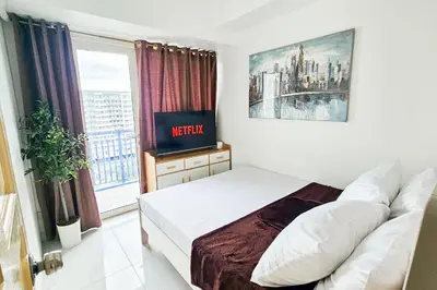 a small bedroom with a bed and a window at 2 Bedroom Condo in Front of SM Mall of Asia in Manila