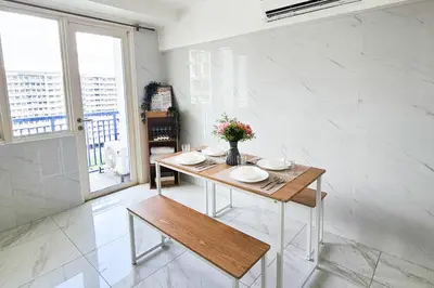 a dining room with a table with flowers on it at 2 Bedroom Condo in Front of SM Mall of Asia in Manila