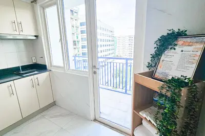 a kitchen with a large window and a door to a balcony at 2 Bedroom Condo in Front of SM Mall of Asia in Manila
