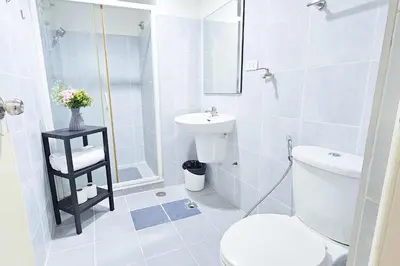 a white bathroom with a toilet and a sink at 2 Bedroom Condo in Front of SM Mall of Asia in Manila