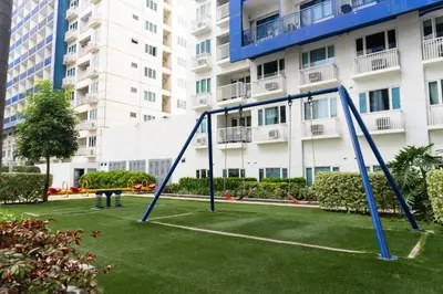 a playground in a park in front of a building at 2 Bedroom Condo in Front of SM Mall of Asia in Manila