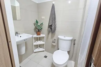 a white bathroom with a toilet and a sink at Condo in SM Mall of Asia MOA near NAIA Airport in Manila