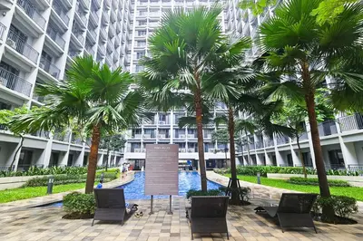 a courtyard with palm trees and a sign in front of a building at Condo in SM Mall of Asia MOA near NAIA Airport in Manila