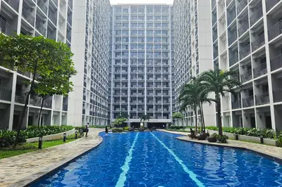 a large swimming pool in front of tall buildings at Condo in SM Mall of Asia MOA near NAIA Airport in Manila
