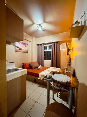 a small room with a bed and a kitchen at PaulBert's Cabins I in Manila