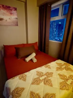 a hotel room with a bed and a window at PaulBert's Cabins I in Manila