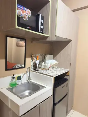 a small kitchen with a sink and a microwave at PaulBert's Cabins I in Manila