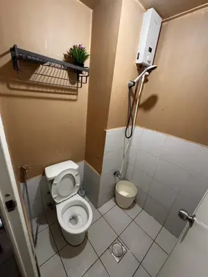 a small bathroom with a toilet in a stall at PaulBert's Cabins I in Manila