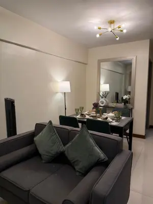 a living room with a couch and a dining room at Staycacia Haven 2BR Condo Maple Acacia Taguig in Manila