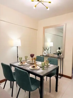 a dining room with a table and chairs and a mirror at Staycacia Haven 2BR Condo Maple Acacia Taguig in Manila