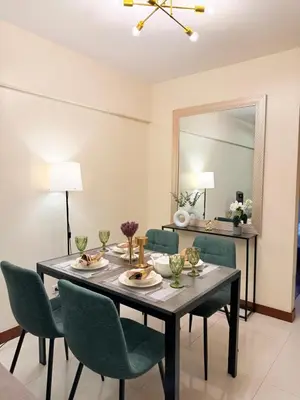 a dining room with a table and chairs and a mirror at Staycacia Haven 2BR Condo Maple Acacia Taguig in Manila