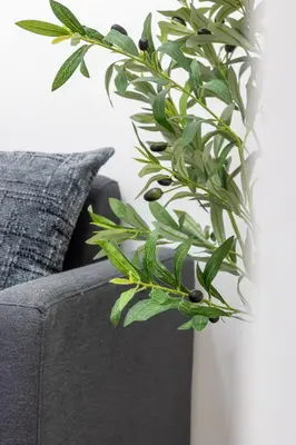 a green plant in a white vase next to a couch at Stylish Makati 1BR w Balcony Netflix and Fast Wifi in Manila