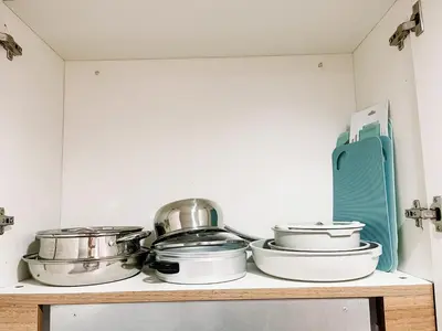 a shelf with pots and pans on it in a kitchen at Stylish Makati 1BR w Balcony Netflix and Fast Wifi in Manila