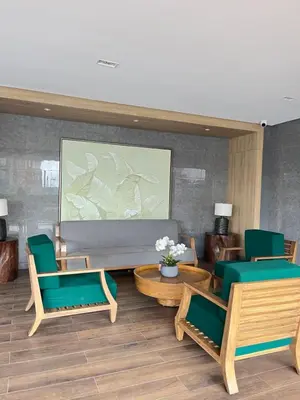 a lobby with green chairs and a large screen at Stylish Makati 1BR w Balcony Netflix and Fast Wifi in Manila