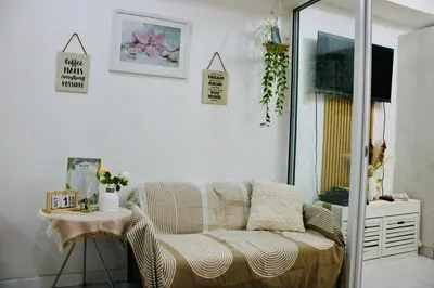 a living room with a couch and a table at Casa Neutra - A Cozy Retreat in Manila in Manila
