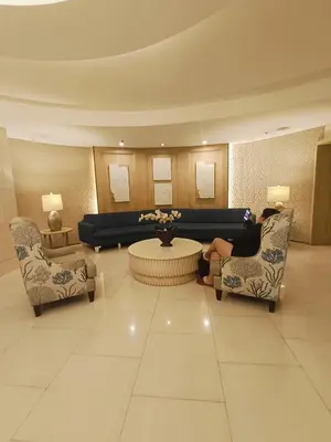 a woman sitting on a chair in a lobby at Shell Residences Mall of Asia by Jhem in Manila