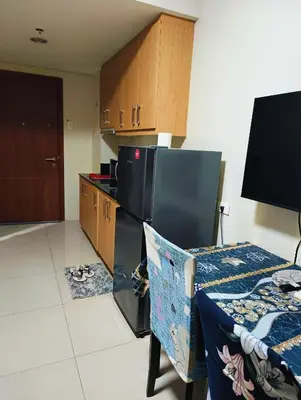 a room with a kitchen with a table and a chair at Shell Residences Mall of Asia by Jhem in Manila