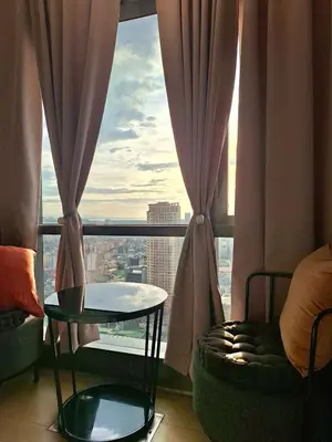 a room with a table and a window with a view at Greenbelt Hamilton Residences by ChiKat in Manila
