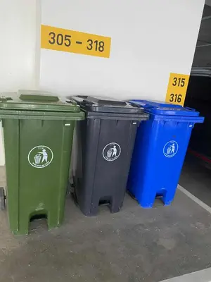 three trash cans lined up next to a wall at Apartment 28 in Manila