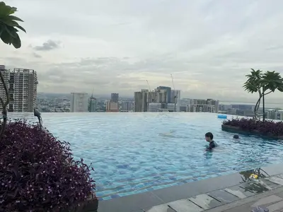 a boy in a swimming pool on top of a building at Apartment 28 in Manila