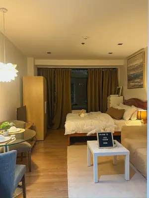 a bedroom with a bed and a table with a laptop on it at Cozy and Aesthetic Vibes - Makati Manila Staycation in Manila