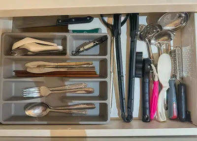 a drawer filled with utensils in a cabinet at Cozy and Aesthetic Vibes - Makati Manila Staycation in Manila
