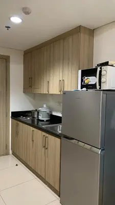 a kitchen with wooden cabinets and a refrigerator at City view in Manila