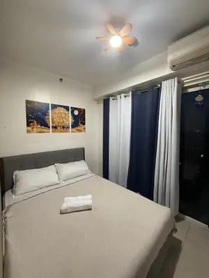 a bedroom with a bed and a ceiling fan at City view in Manila