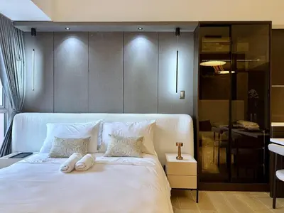 a bedroom with a white bed with two towels on it at Venice Canal View with Balcony near BGC and Airport 10c in Manila