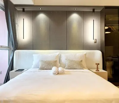 a large white bed with two towels on it at Venice Canal View with Balcony near BGC and Airport 10c in Manila