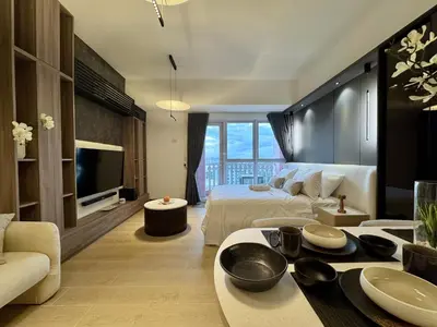 a hotel room with a bed and a television at Venice Canal View with Balcony near BGC and Airport 10c in Manila