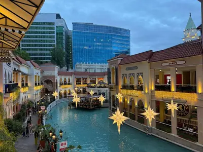 a shopping mall with a river in the middle at Venice Canal View with Balcony near BGC and Airport 10c in Manila