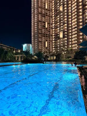 a large swimming pool in front of a large building at Prisma Residences - 1 Bedroom Paid Parking & Kitchen Near BGC in Manila