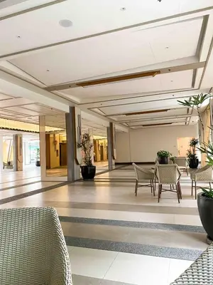 a lobby with chairs and tables in a building at Prisma Residences - 1 Bedroom Paid Parking & Kitchen Near BGC in Manila