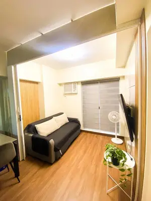 a bedroom with a bed and a television in a room at Prisma Residences - 1 Bedroom Paid Parking & Kitchen Near BGC in Manila
